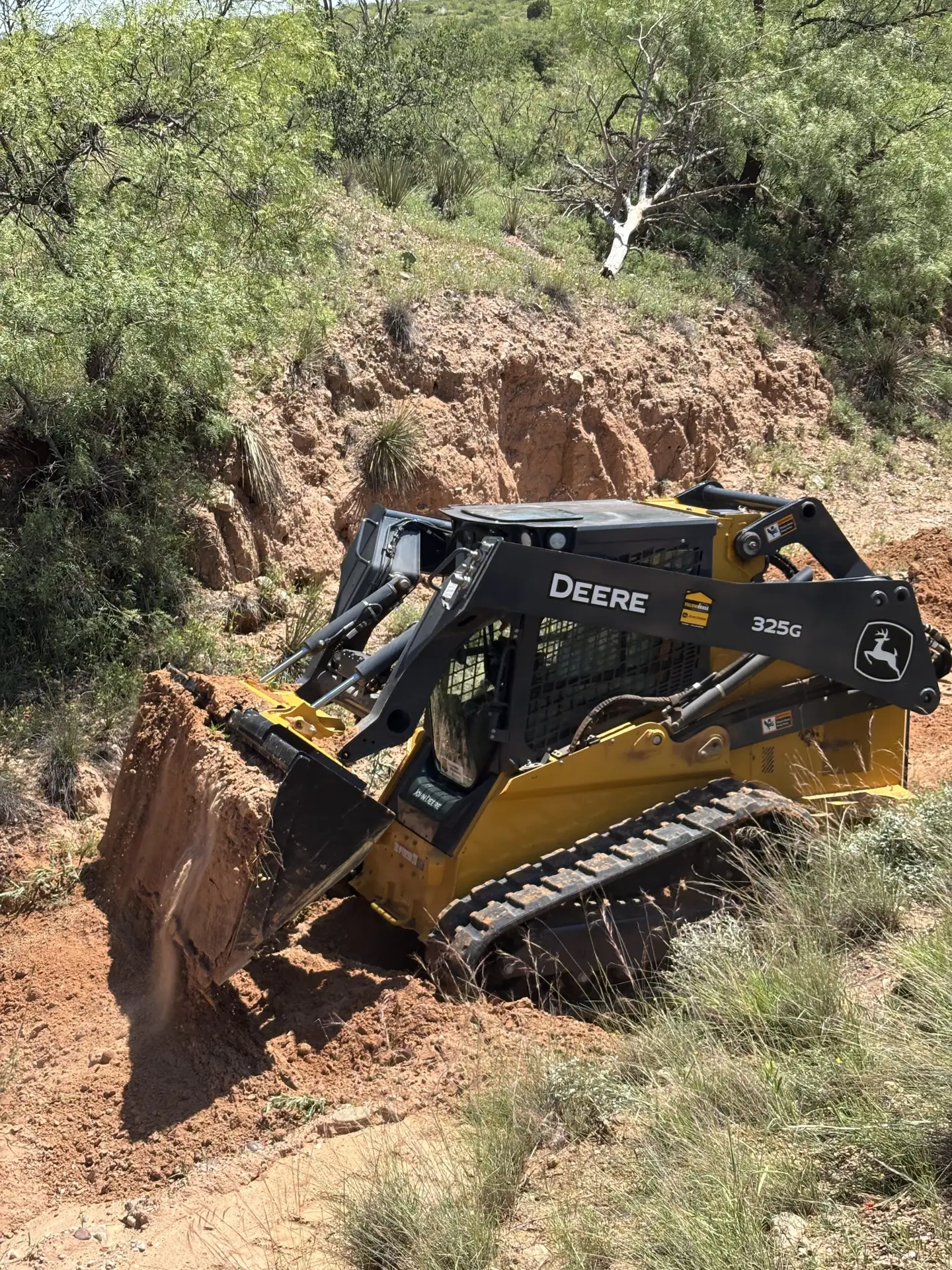 A John Deere Compact Track Loader moving dirt in agriculture and construction applications