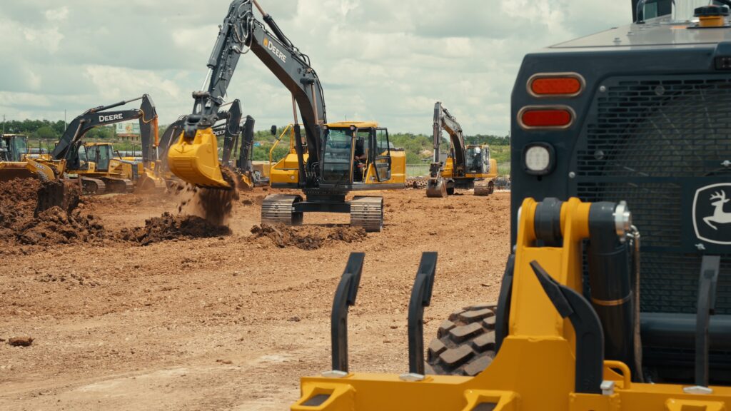 John Deere 210 P-Tier excavator digging on a jobsite